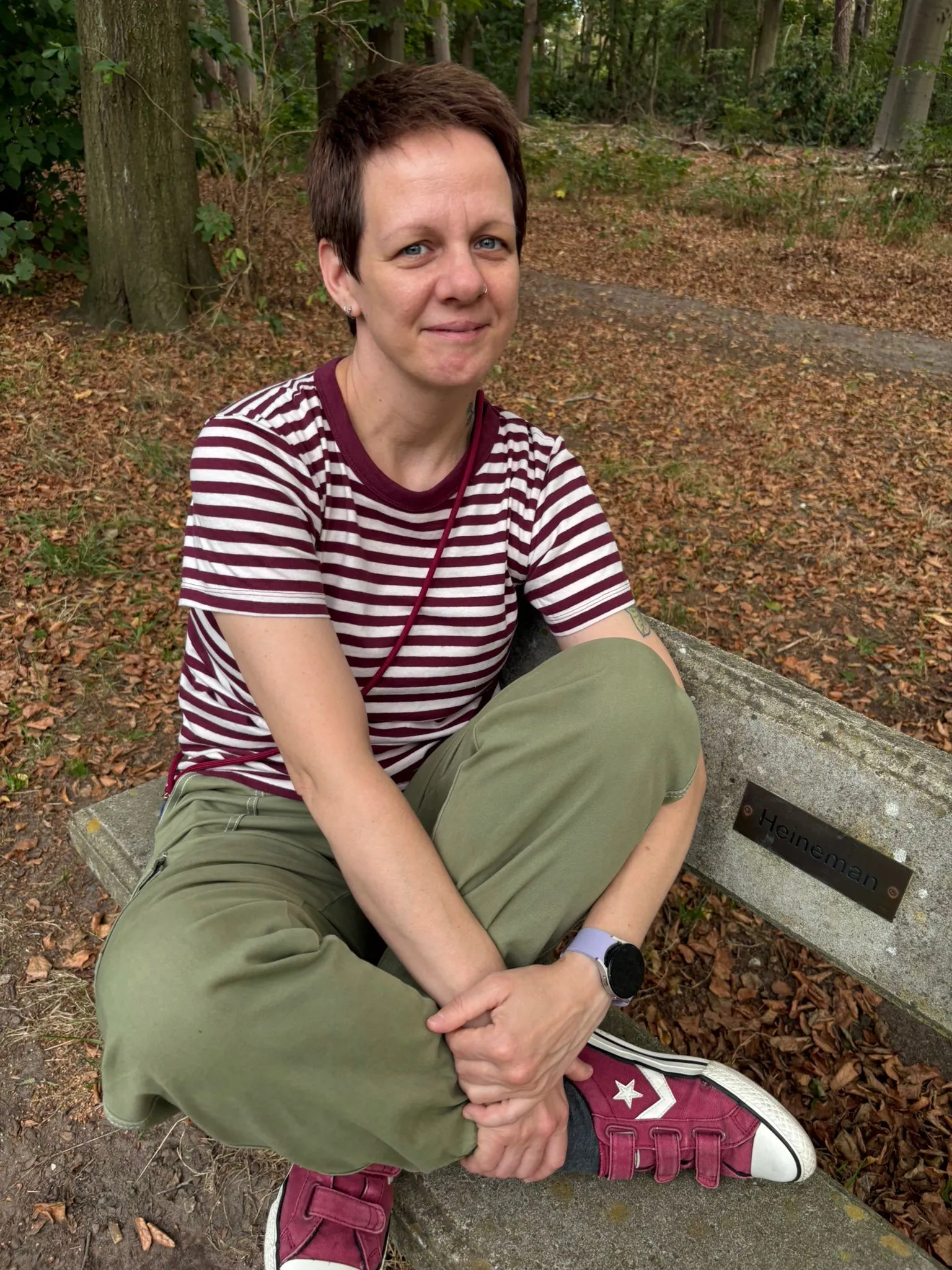 Portret van de masseuse van Relax Bridge, zittend op een bankje in het bos.
